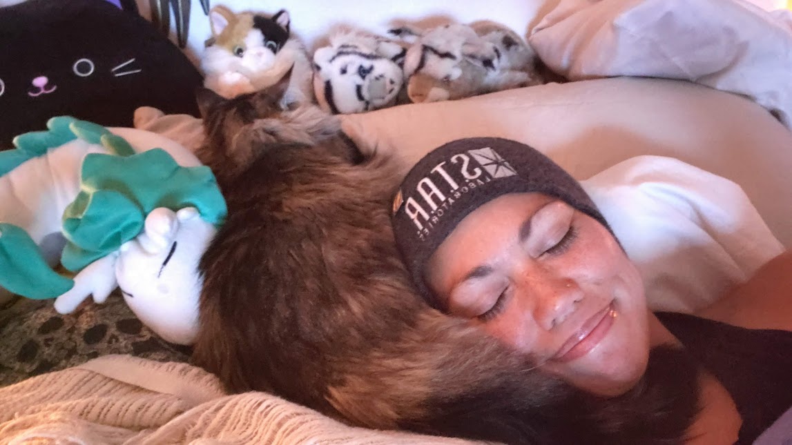 Malia resting with Teja, one of the cats who helped shape DharmaCats Sanctuary, curled beside her